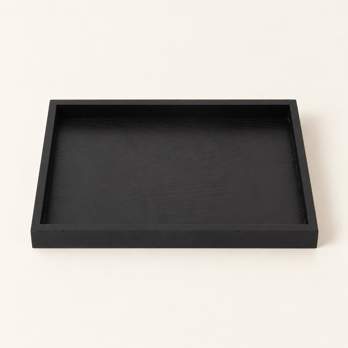 Black wooden serving tray in the cream studio